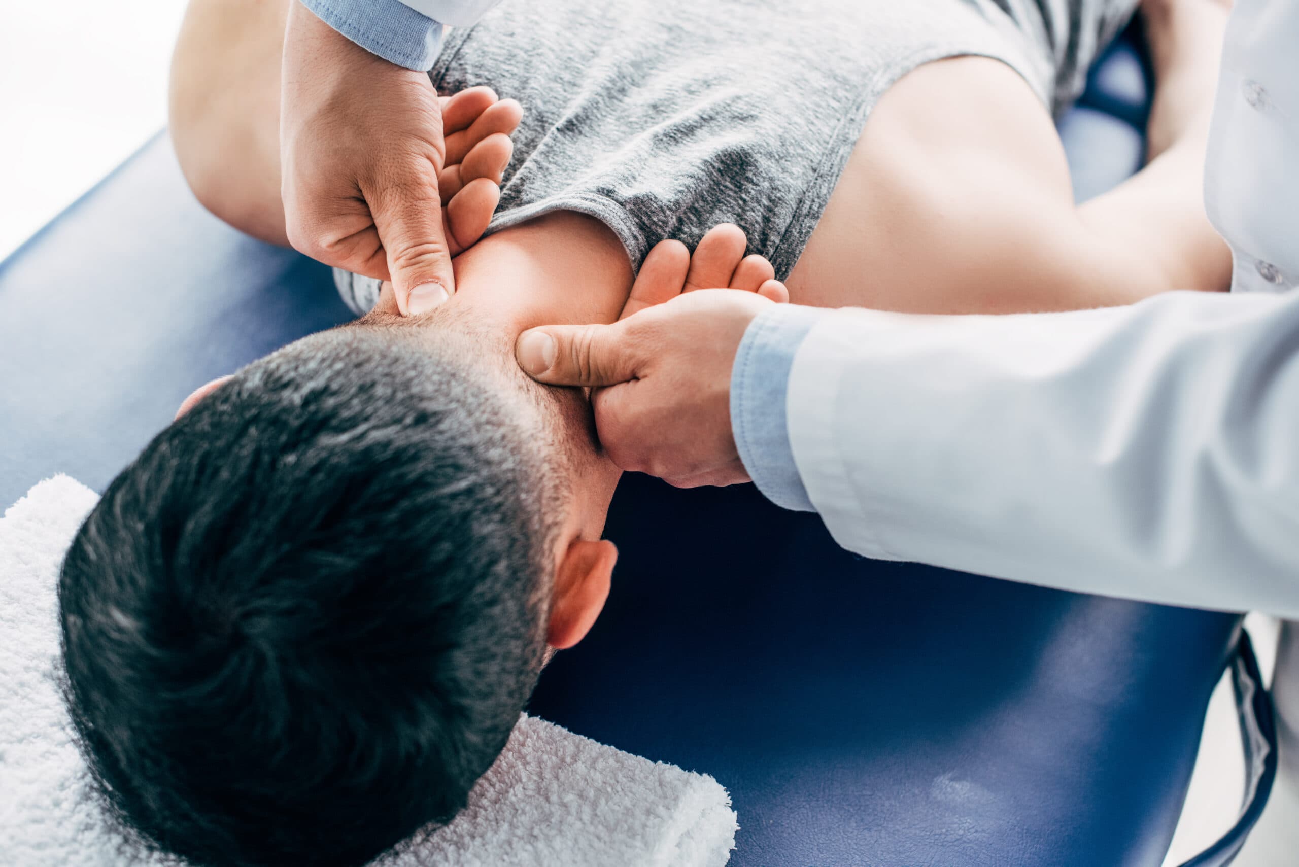 Chiropractor providing neck adjustment to a patient during chiropractic care session in Farmington, UT.