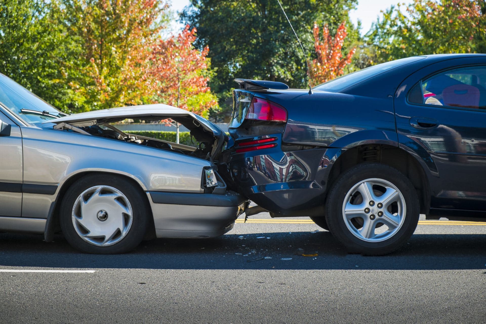Auto accident scene with a silver car and a black car colliding, showcasing damage to both vehicles, emphasizing the need for auto accident care in Woods Cross, UT.